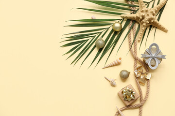 Starfish, palm branch, rope with Christmas decoration on beige background. Top view