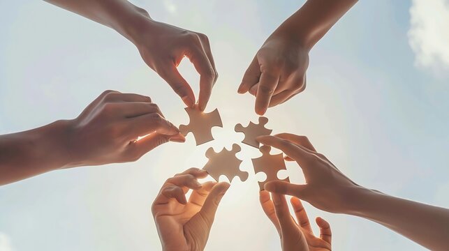 Teamwork and partnership concept Hands are raised against a bright white sky each holding a piece of a wooden jigsaw puzzle teamwork problemsolving Charity volunteer Unity team busines : Generative AI