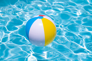 Summer swimming pool. Beach ball in swimming pool. Summer vacation advertising. Beach ball. Ball in the swimming pool. Summer vacation. © Korneliia