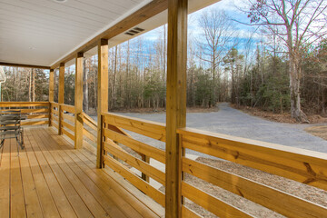 Wide Wooden Porch With Natural Railing Set Amidst A Serene Forest Background in Winter