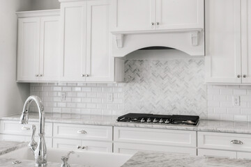 Elegant Kitchen With Herringbone Backsplash And Marble Countertops