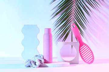 Hair spray with brush and scrunchy on light color background