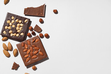 Composition with tasty chocolate bars and nuts on grey background