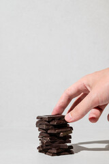Hand picking up chocolate pieces from the table