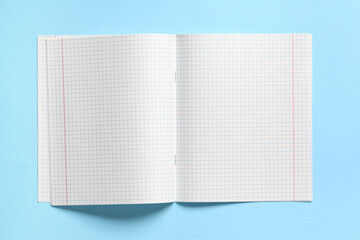 Open copybook with blank pages on blue background