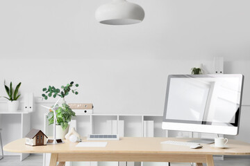 Fototapeta premium Engineer's workplace with computer, wind turbine and house model in office