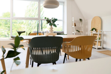 Vase with eucalyptus branches on dining table in room
