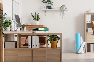 Interior of engineer's office with shelf unit, plants and wind turbine models