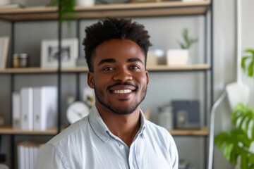 Naklejka premium Happy young African American man poses for close up headshot in home office