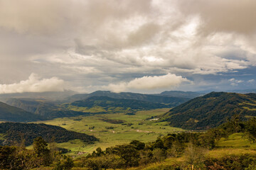 Fototapeta premium The magnificent landscape of the eastern Andean mountains of central Colombia, illuminated by the light of sunset on an overcast sky.