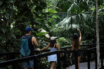 Group of friends hiking on a wooden pathway on Costa Rica