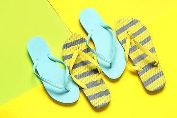 Different stylish flip-flops on yellow background