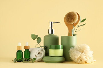 Composition with bath supplies, cosmetic products and eucalyptus branches on color background