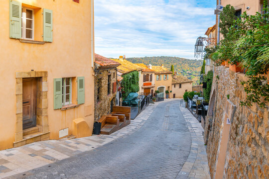 Fototapeta A colorful, winding hillside street in the picturesque village of Ramatuelle, France, in the  Var Department of the Provence, Alpes Cote d'Azur region.