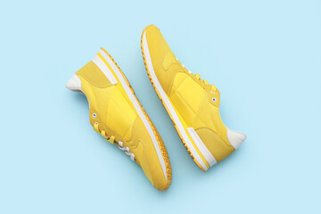 Stylish male yellow sneakers on blue background