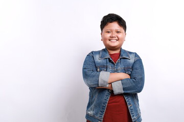 Happy young Asian boy in casual outfit with arms crossed isolated over white background