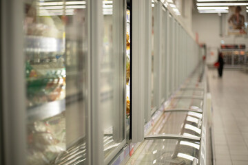 Refrigerator in the store. Showcase with products. Cabinet for freezing food.