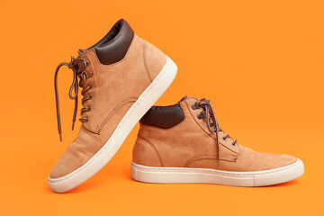 Stylish male brown shoes on orange background