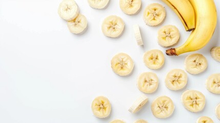 Fototapeta premium Healthy snack Top view of delicious banana slices on white backdrop with text space