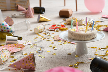 Birthday cake with confetti on carpet in living room after party, closeup