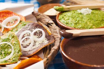 Super closed plan of natural fiber basket end containing group of various toasts covered with different sauces of exotic flavors.