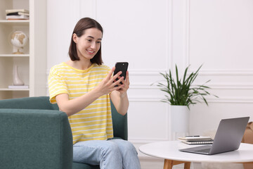 Woman with good posture using smartphone at home