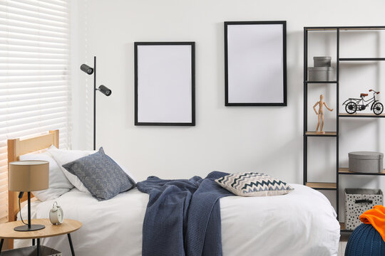 Teen's room interior with modern furniture and empty frames on wall