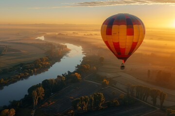 Obraz premium Hot air balloon flight over a river at sunrise.