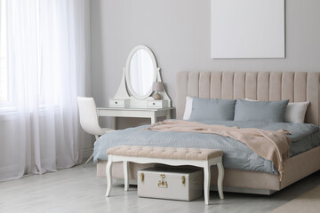 Stylish contemporary bedroom interior with ottoman and comfortable bed