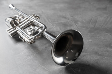 Obraz premium Closeup view of shiny trumpet on grey textured table. Wind musical instrument