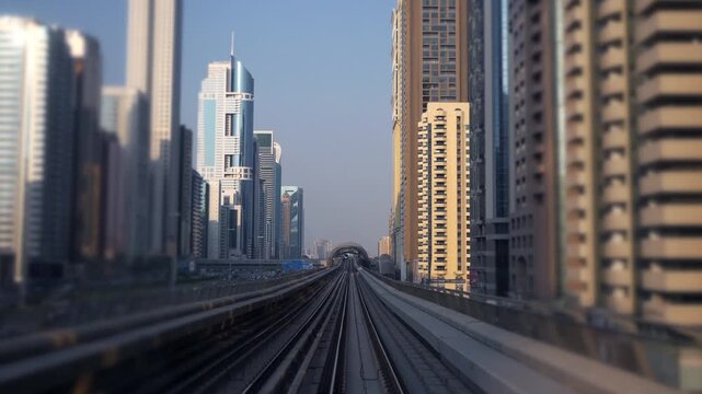 A contemporary urban train track cutting through towering skyscraper buildings in a cityscape view