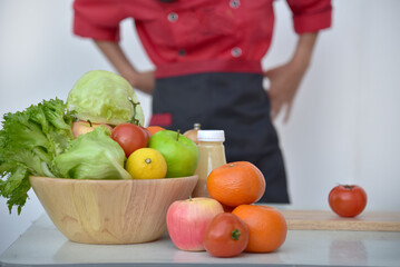 Close up Women Chef hand cutting slice red tomato prepare fruit vegetables. Crop Woman hands use knife chopping organic tomato. Females Chef hands holding chop Wooden cutting board home kitchen