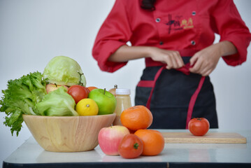 Close up Women Chef hand cutting slice red tomato prepare fruit vegetables. Crop Woman hands use knife chopping organic tomato. Females Chef hands holding chop Wooden cutting board home kitchen