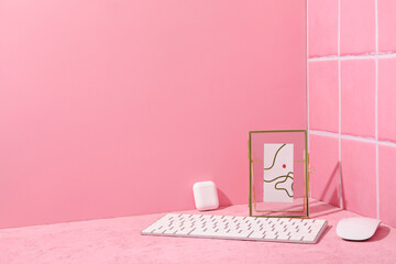 Computer keyboard with mouse and cassette on a pink background