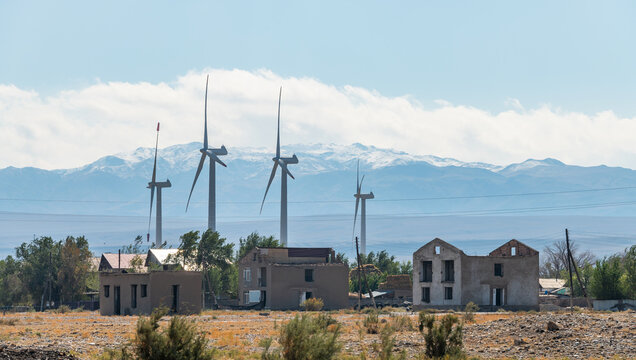 Windmills and dilapidated abandoned houses in Almaty region (Kazakhstan) on a sunny day - Powered by Adobe