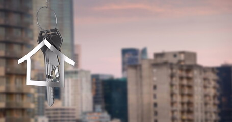 Image of silver house key over cityscape