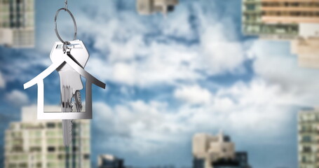 Image of silver house key  over cityscape
