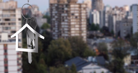 Image of silver house key over cityscape
