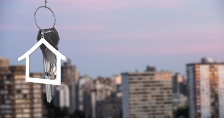 Image of silver house key over cityscape
