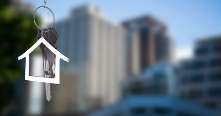 Image of silver house key over cityscape