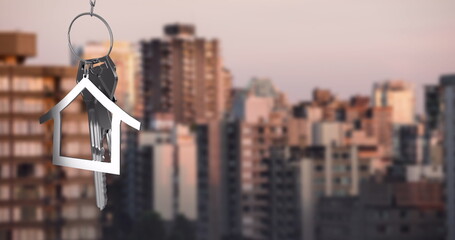 Image of silver house key over cityscape
