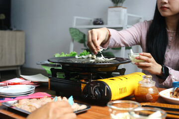 Young Asian Woman Sprinkle Onions Into Grill. Asian Barbeque Concept