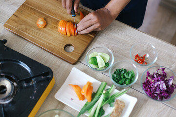 Top View Of Man Hands Slicing The Tomatoes On Wooden Board. Slicing Ingredients To Make Indonesian Chicken Soup