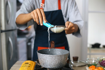 Man Hands Cook The Vermicelli While Draining At Kitchen. Preparation For Making Chicken Soup With Rice Noodles