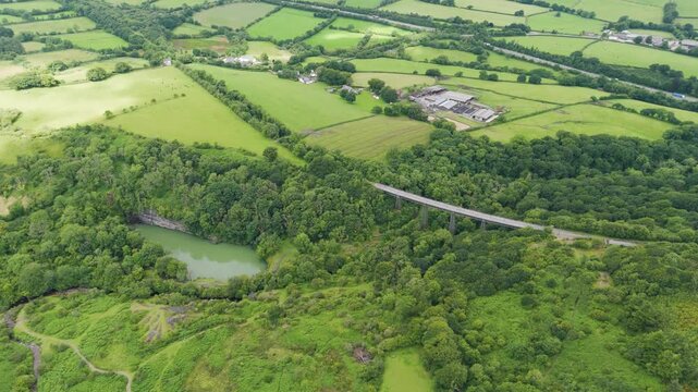 Aerial establishing shot of Meldon Viaduct showcasing the historic structure amidst lush greenery and rolling hills