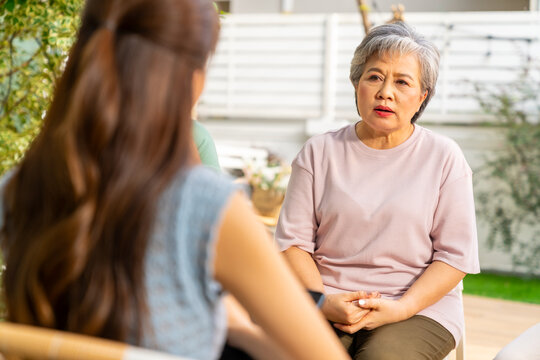 Group of Asian senior mature woman talking discussion about mental health life problem thoughtful with professional psychiatrist in the garden. Elderly people mental health care and therapy concept. - Powered by Adobe