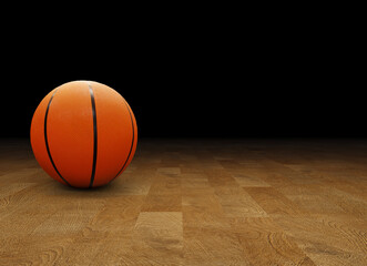 basketball ball on wooden floor with black background.