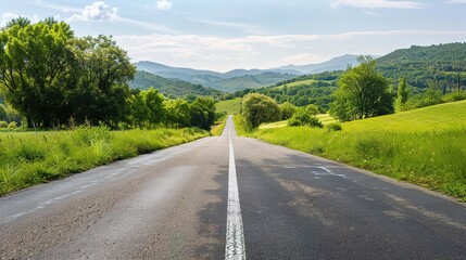Fototapeta premium Scenic Open Road Surrounded by Lush Greenery and Gentle Hills: A Serene and Peaceful Natural Landscape