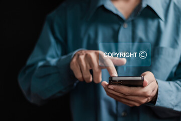 Copyright or patent concept. businessman using smartphone with copyright text on virtual screen for author rights and patent intellectual property