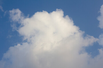 It's a blue sky with atmospheric puffy clouds.